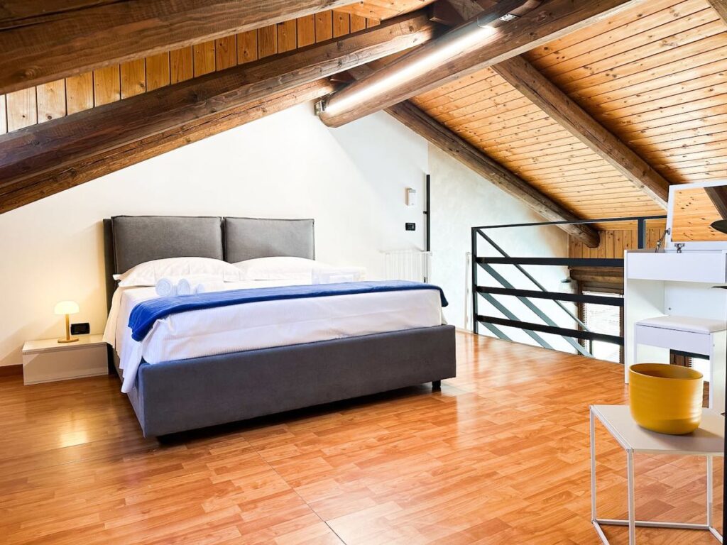 La camera con il letto matrimoniale sotto le travi